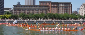 Dragon boats fly past the Astor Hotel